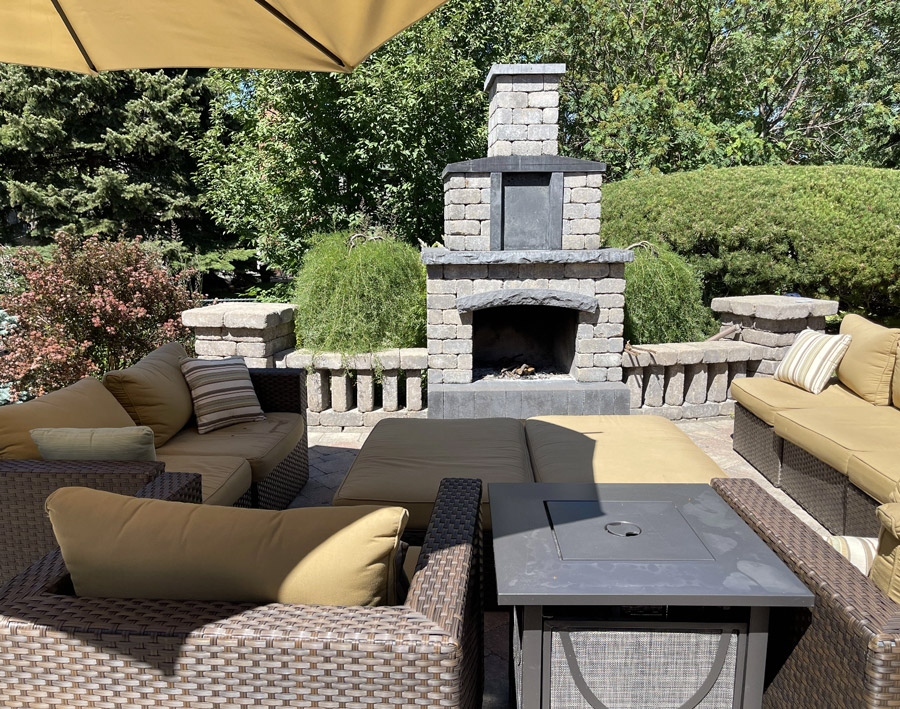 Outdoor patio with stone fireplace and seating area